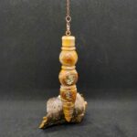 Je suis un pendule en Abricotier, mon arbre a fendu lors d’une tempête en Charente maritime. Au lieu de terminer au feu, je suis devenu un pendule de radiesthésie. Je porte en moi la grandeur de mon arbre qui continue de vivre dans mes courbes et le veinage de mon bois si précieux. Je serai bientôt ton allié et nous partagerons une histoire ensemble comme chaque oiseau qui s’est posé sur ma branche.