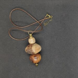 Très beau collier Traversé par une tige métal couleur bronze composé de 3 perles de bois d'abricotier tournées artisanalement de la marque Howood avec bois du jardin en Charente-Maritime