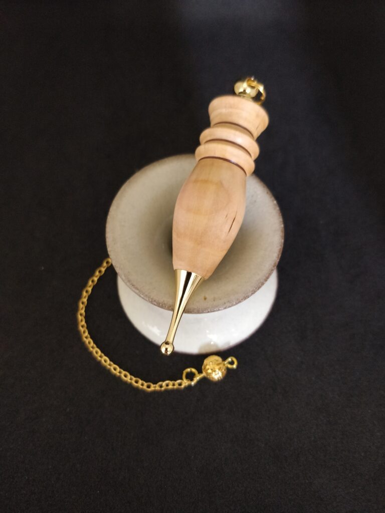 Pendule de radiesthésie artisanal égyptien mirabellier et métal doré.
